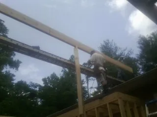 Carpenter setting a ridge beam over a new addition frame — Ice Dam Removal by Roofing Brothers in Philippi