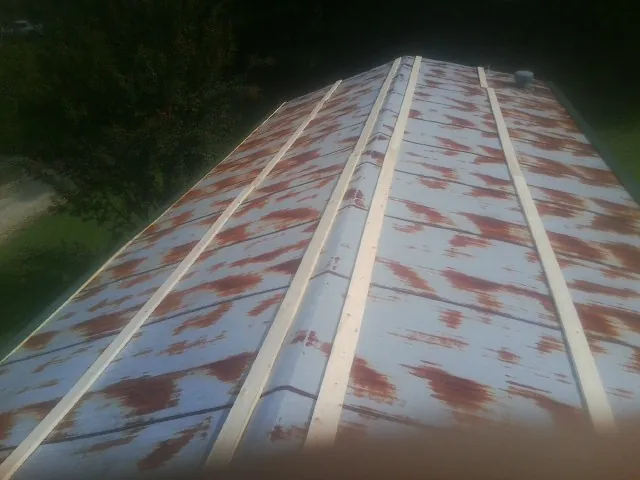 Rusted metal roof panels with new wood purlins before replacement — Storm Damage Roof Repair in Philippi by Roofing Brothers