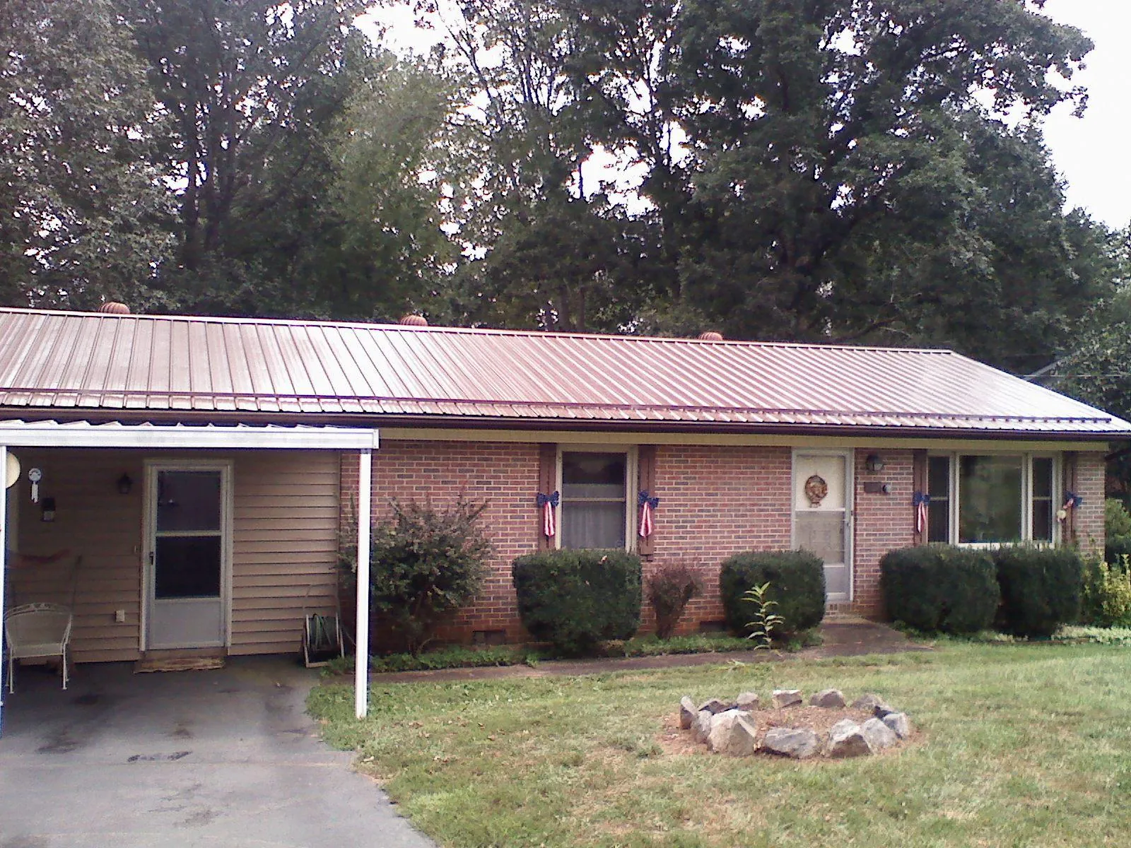 Bronze metal roof and carport on a brick ranch home — Roof Repair work by our crew in Philippi